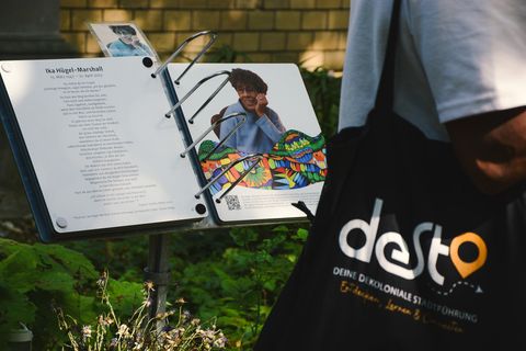 Close-up of a tour guide's printed materials and a Desta tote bag